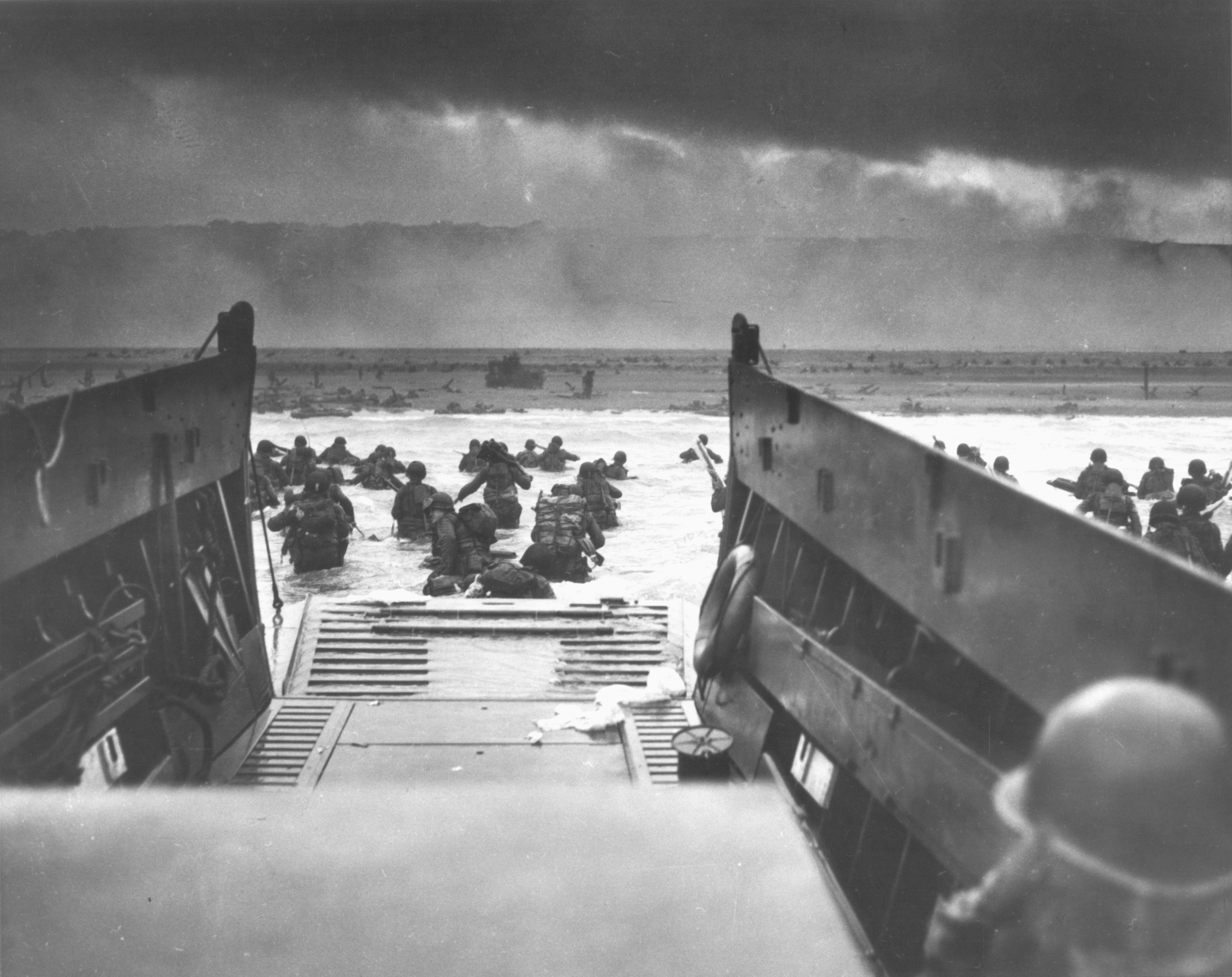American assault troops wading through the surf toward the Normandy shore from a landing craft, 6 June 1944.